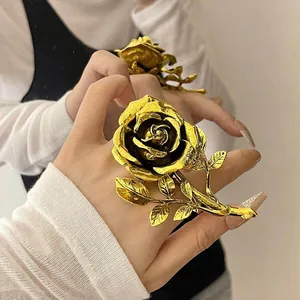 Macro detail of vintage gold rose flower ring featuring a detailed leaf stem band