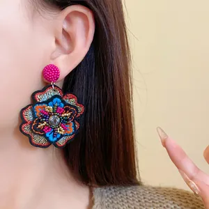 Close-up detail of vintage embroidered flower earring with colorful beads and sequins