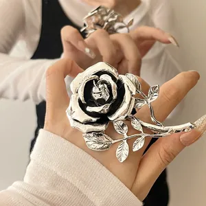 Detail view of a vintage silver rose ring with intricate petal and leaf design.