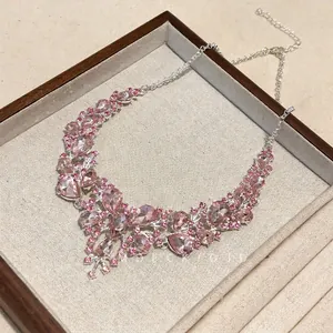 Close-up of elegant pink teardrop rhinestone necklace in a vintage wooden display tray