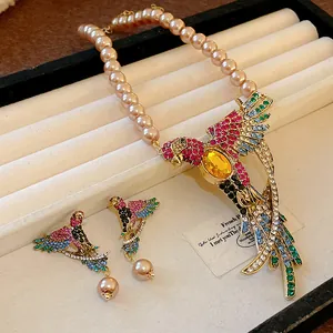 Macro detail of the ornate parrot pendant with vibrant crystals and elegant champagne pearls.