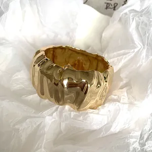 Macro shot of the irregular wrinkled texture on a wide-surface gold bangle bracelet