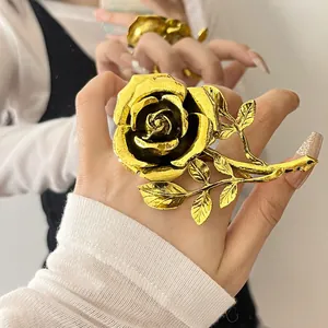 Vintage gold rose flower ring with stem and leaf detailing shown on a model's hand