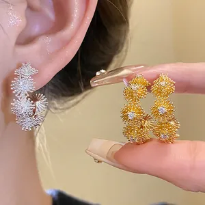 Elegant gold and silver starburst zircon earrings with high-sparkle luxury design