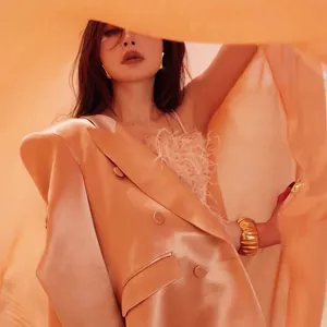 Detailed view of an irregular pleated gold wide cuff bracelet styled on an elegant model