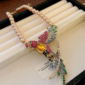Detailed view of vintage palace style necklace with rhinestone bird and faux pearls
