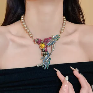 Detail view of vintage bird wing necklace with multi-color rhinestones and faux pearls.