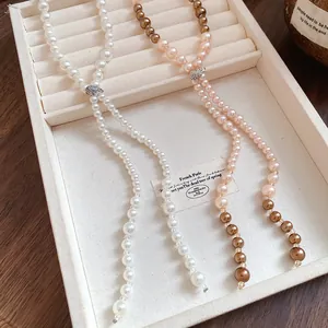 Detailed macro shot of long pearl tassel necklaces with sparkling rhinestone accents