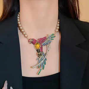 Close-up of vintage palace style necklace with rhinestone bird and faux pearls