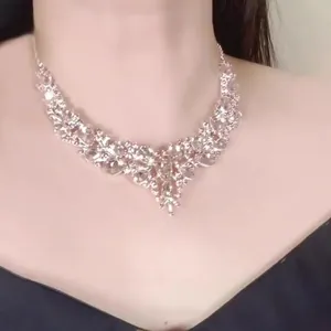 Detailed view of a sparkling teardrop rhinestone necklace worn on a model's neck