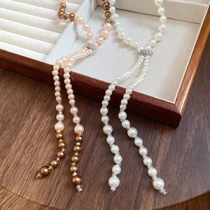 Detailed view of elegant pearl tassel necklaces with shimmering diamond-studded clasps.