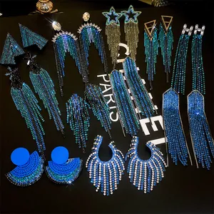 Close-up detail of various sparkling rhinestone tassel and geometric fringe earrings