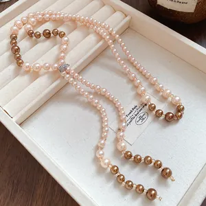 Elegant French style long pearl tassel necklace displayed in a cream jewelry tray
