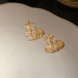 Close-up of sparkling heart-shaped stud earrings with gold plating and cubic zirconia