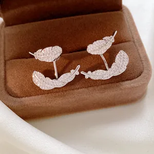 Detailed view of elegant silver feather stud earrings encrusted with sparkling pavé zircons.