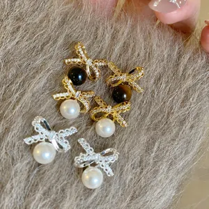Nahaufnahme von eleganten Schleifenohrringen mit Perlen und Zirkoniasteinen