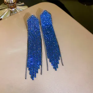Detailed view of long electric blue rhinestone tassel earrings with silver studs