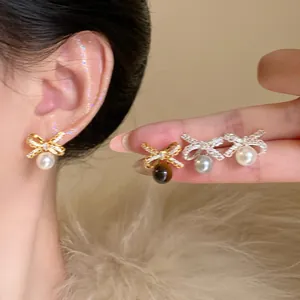 Detailansicht der Schleifenohrringe mit Perlen und Zirkonia in Gold und Silber.
