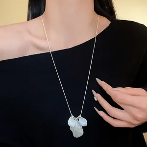 Elegant long necklace featuring irregular matte silver petal pendants on a model.