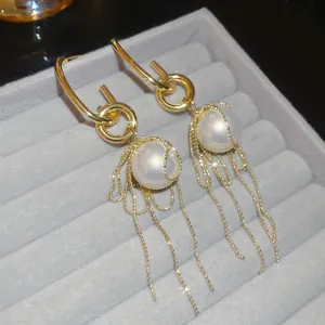 Elegant gold pearl earrings with delicate tassel chain details in velvet box