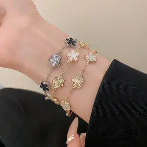 Close-up shot of elegant gold and silver plated flower charm bracelets worn on a wrist.
