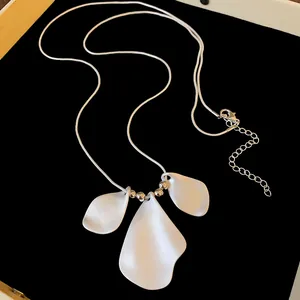 Detail view of minimalist irregular folded petal necklace with matte white finish