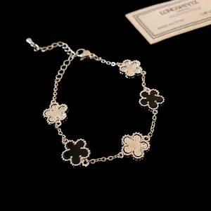 Detailed view of silver-tone flower bracelet with black and textured charms