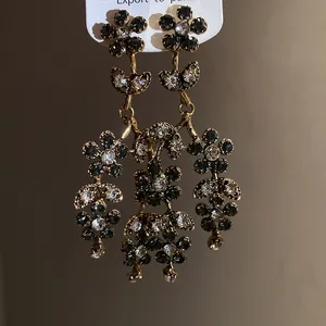 Detailed view of vintage floral drop earrings with grey and clear rhinestones