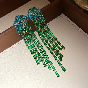 Exquisite close-up of luxury green baguette zircon and blue crystal long tassel earrings