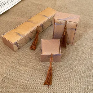 Close-up detail of champagne gold silk jewelry boxes with tassel accents