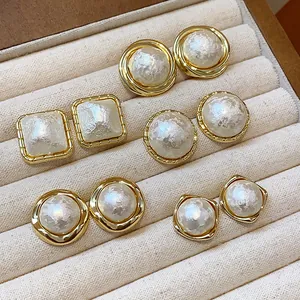 Vista detallada de varios pendientes de perlas de algodón bañados en oro en estuche