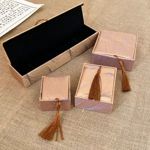 Detailed view of elegant jewelry boxes with feather patterns and decorative tassels.