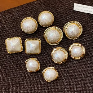 Primer plano de pendientes de perlas de algodón chapados en oro en formas vintage