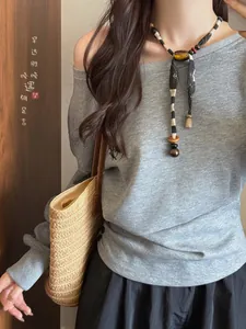 Minimalist ethnic fabric and wooden bead necklace styled on a model in a casual setting.