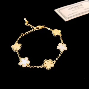 Close-up of gold-plated bracelet with textured and shell flower charms