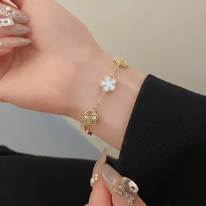 Macro view of a gold-plated flower bracelet with beaded edges and white inserts