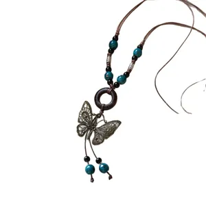 Collier rétro de style ethnique avec pendentif papillon, perles en céramique et anneau bois.