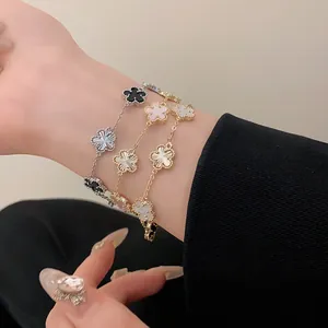 Close-up view of three gold and silver flower charm bracelets elegantly worn on a lady's wrist
