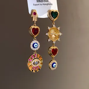Asymmetric gold dangling earrings with heart and evil eye zircon details