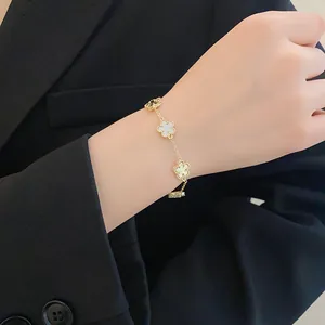 Detailed close-up view of an elegant gold plated flower bracelet on model's wrist