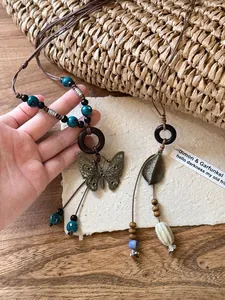 Gros plan d'un collier ethnique rétro avec papillon ajouré et perles en céramique