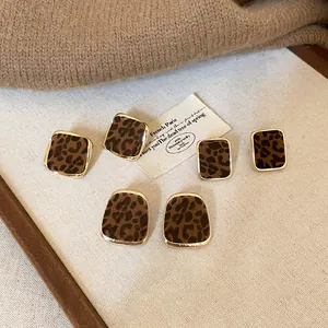 Detailed close-up of retro leopard print flocked square earrings with gold frames