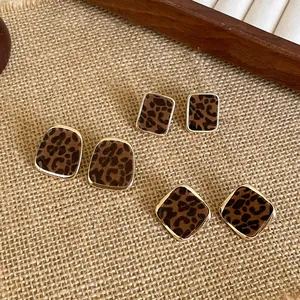 Close-up showing vintage leopard print flocked earrings in three distinct geometric shapes