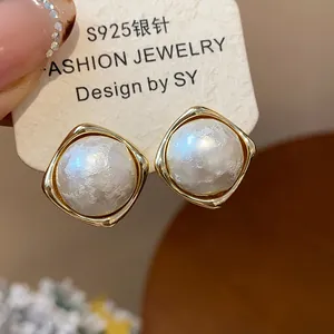 Elegantes pendientes de botón redondos dorados con perlas de algodón