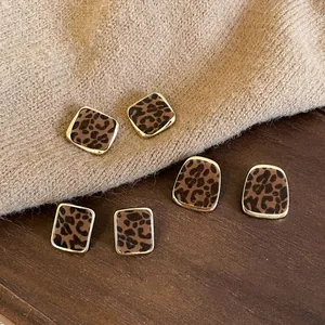 Detail view of vintage flocked leopard print square stud earrings in gold frames