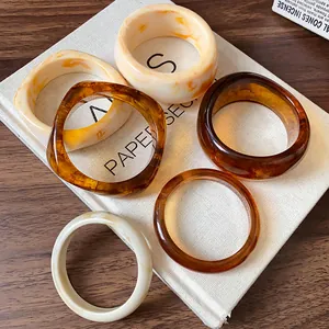 Macro detail of vintage irregular resin bangles in amber and marble white finish