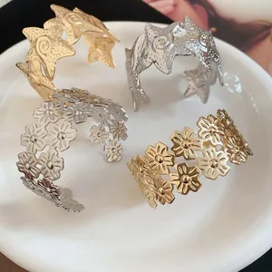 Elegant gold and silver metal bangles featuring star and floral cutout designs on a plate