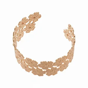 Rose gold metal cuff bracelet with delicate cutout floral patterns, stylish and elegant.