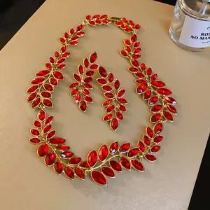 Vogelperspektive auf ein Vintage-Schmuckset mit vergoldeten roten Blattkristallen.