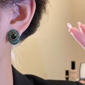 Vintage oval emerald green gemstone stud earrings with exquisite rhinestone detailing